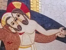 القدّيس بيو يعانق المسيح المصلوب وهو يحمل جراحاته (موزاييك جداريّة في مزار سيّدة النعم في سان جيوفانّي روتوندو-إيطاليا، تصميم الأب ماركو روبنيك اليسوعي)